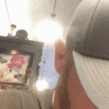 a man wearing a hat is looking at a picture