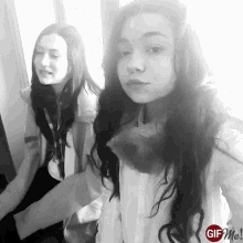 a black and white photo of two girls with a gif me logo on the bottom right