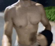 a shirtless man is running down a street while wearing a wristband .
