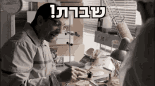 a man sitting at a desk with a sign above him that says ' sbara '