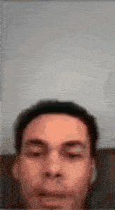 a blurry picture of a man 's face with his eyes closed and his mouth open .