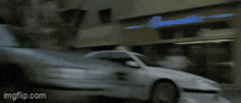 a white car is driving down a street with imgflip.com written on the bottom right