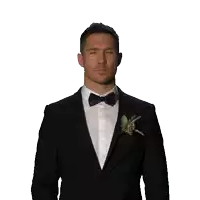 a man in a tuxedo and bow tie looks up at something
