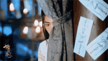 a man peeking out from behind a curtain with chinese writing on the papers