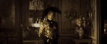 a woman wearing a black hat and gloves is standing in a dark room