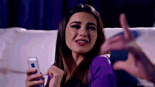 a woman sitting on a couch holding a cell phone with editsmalta written below her