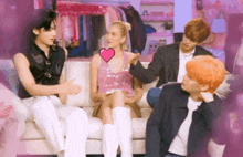 a woman in a pink dress is sitting on a couch with three men