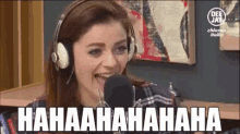 a woman wearing headphones is laughing in front of a microphone that says ' hahaaahahaaa ' on it