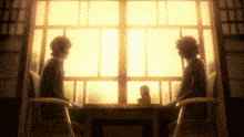 two people are sitting at a table in front of a window talking .