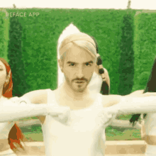a man wearing a headband and a white tank top is dancing in front of a green wall with the word reface app visible