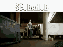 a man is standing in front of a dumpster with the word scubahub on the top