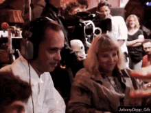 a man wearing headphones is sitting next to a woman with blonde hair
