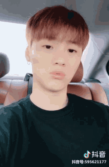 a young man in a black shirt is sitting in the back seat of a car with the number 59562177 on the bottom