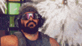 a man with a beard wearing sunglasses and headphones looks at the camera