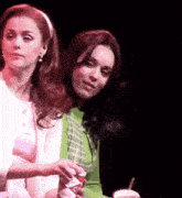 two women sitting next to each other on a stage