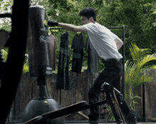 a man is hitting a punching bag outside