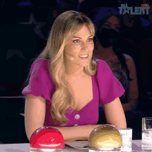 a woman in a purple top sits at a table with a sign that says star talent on it