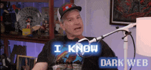 a man is sitting in front of a microphone and says i know