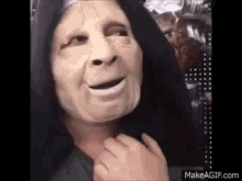 a person wearing a mask with a hood on their head is making a funny face .