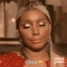 a woman is wearing a red dress and earrings and making a tired face .