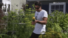 a man in a white shirt is standing in front of a house with the bug-a-salt logo on the bottom
