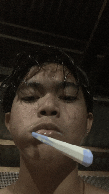 a young man is brushing his teeth with a toothbrush