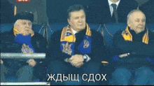 a man wearing a scarf with the word ukraine on it is smiling