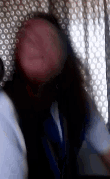 a blurry picture of a woman 's face in front of a bubble wrap curtain