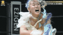 a woman in a wrestling ring with a sign that says ezigen