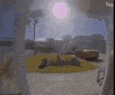 a car is parked in a driveway in front of a house and the sun is shining through the window .
