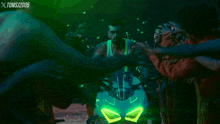 a man on a motorcycle is surrounded by a crowd of people with xtoms written on the bottom left