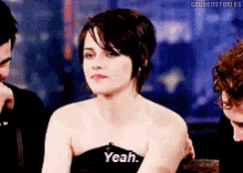 a woman in a black dress says yeah in front of a man