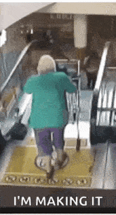 an elderly woman is riding an escalator in a mall .