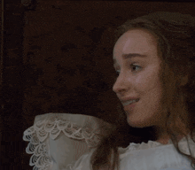 a woman in a white lace dress is smiling