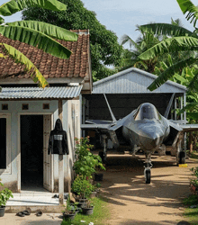 a fighter jet is parked in front of a house with a hoodie that says i am a fighter jet