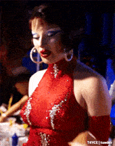 a woman in a red dress with sequins and hoop earrings is on tumblr