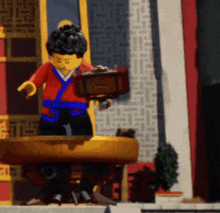 a lego figure standing on a table with a briefcase in his hand