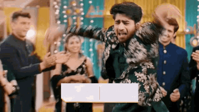 a man is dancing in front of a crowd of people at a party .