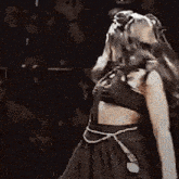 a woman in a black dress is dancing in a crowd