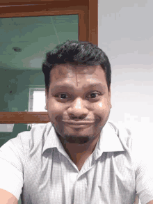 a man with a beard and a white shirt is smiling and looking at the camera