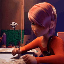 a girl with pink hair is sitting at a table with a brush