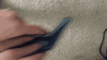 a person is holding a pair of scissors over a carpet