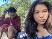 a boy and a girl are posing for a picture and the girl is wearing a necklace that says heart