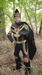 a man in a costume with a crown on his head stands in the woods