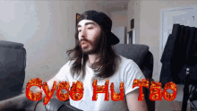 a man with long hair is wearing a hat and a white shirt that says cycoe hu tao