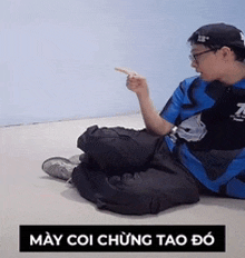 a man is sitting on the floor and pointing at something