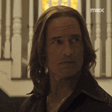 a close up of a man 's face with a max logo in the background