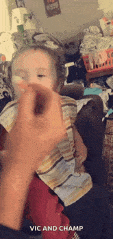 a little girl is sitting on a couch being held by a man .