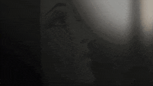 a person 's face is shown in a dark room