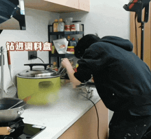 a person cooking in a kitchen with chinese writing on the wall behind them